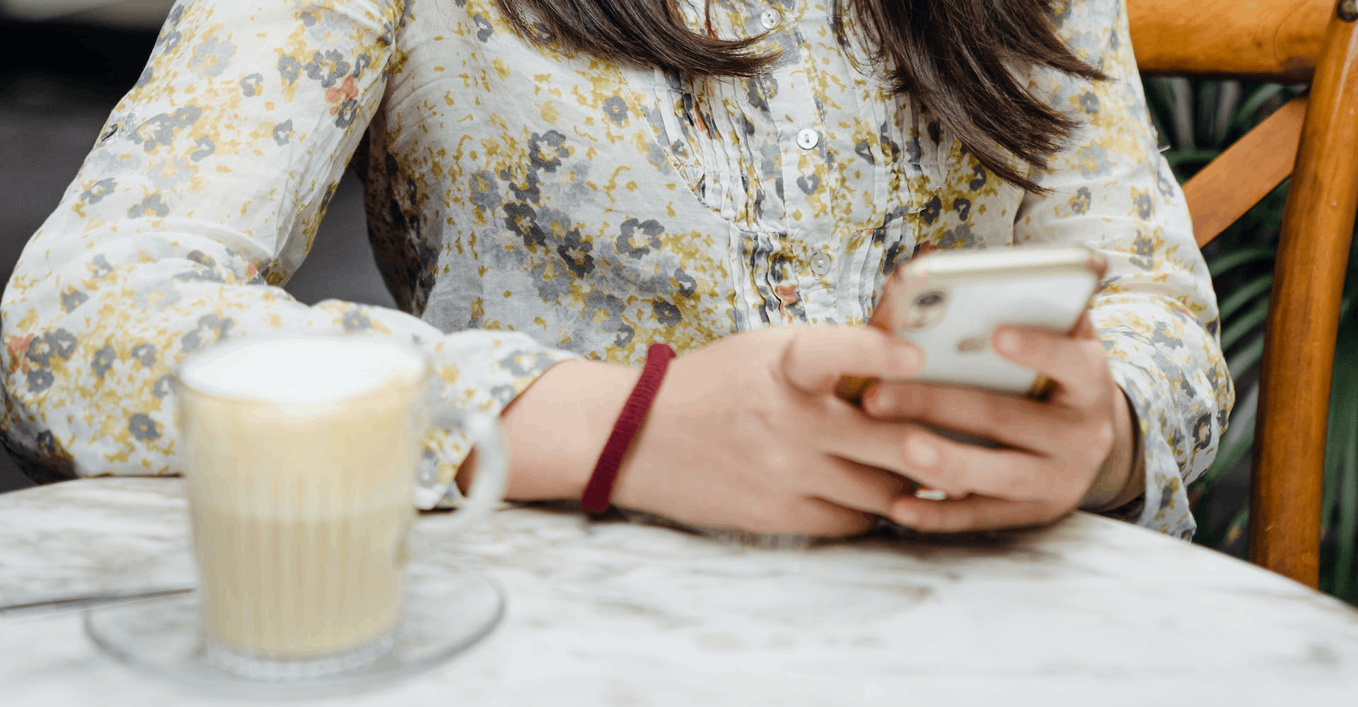 Frau mit Cafe und Handy, Foto von Ketut Subiyanto